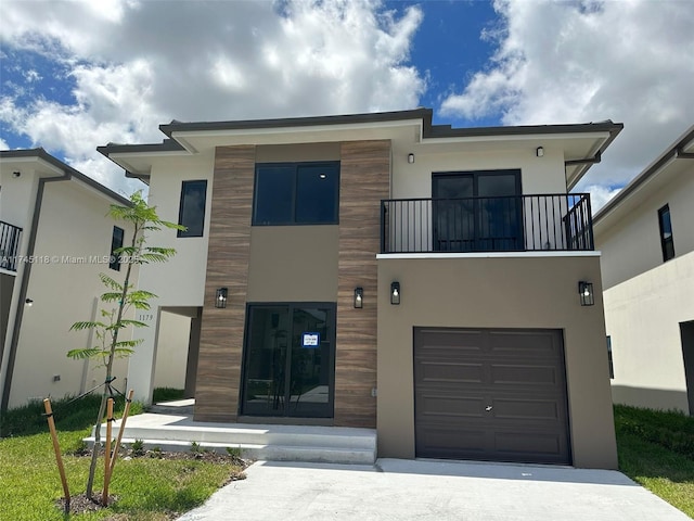 modern home with an attached garage, a balcony, and stucco siding