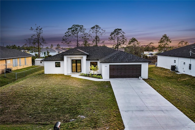 view of front of house with a garage, concrete driveway, a front lawn, and cooling unit