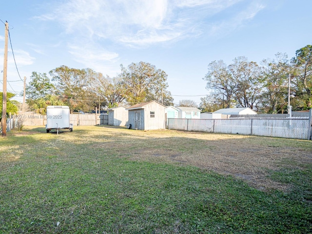 view of yard featuring a storage unit, an outdoor structure, and a fenced backyard