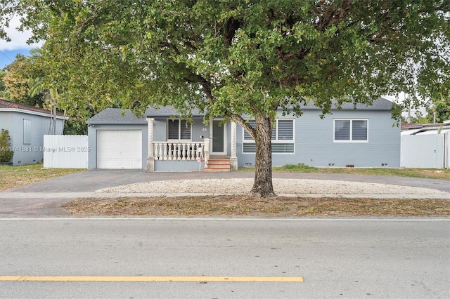 view of front of house with a garage, aphalt driveway, crawl space, and fence