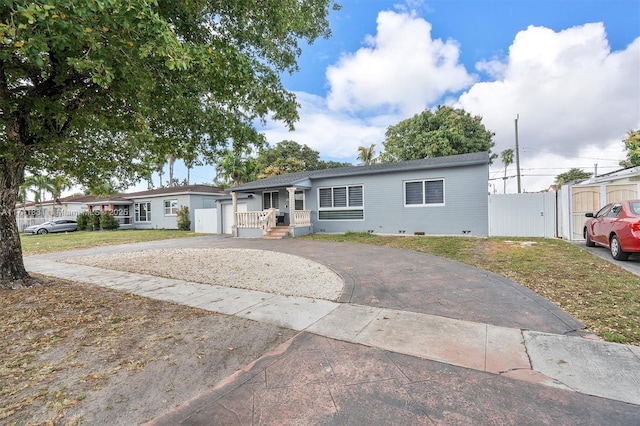 view of front of property featuring crawl space, a gate, fence, and aphalt driveway