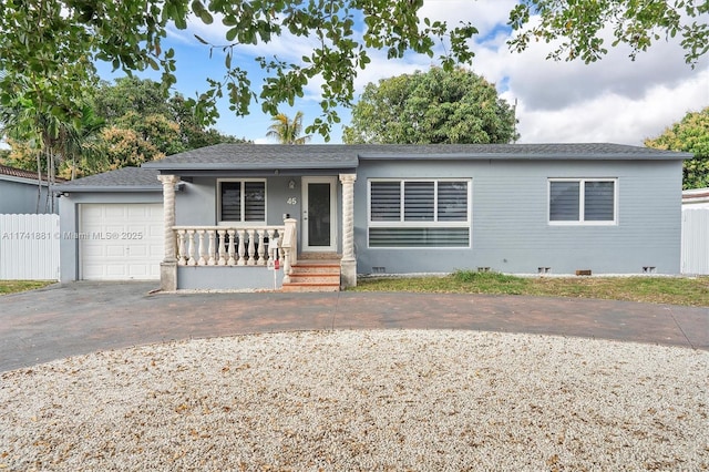 ranch-style house with a garage, covered porch, and decorative driveway