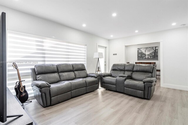 living room with light wood-style floors, recessed lighting, and baseboards