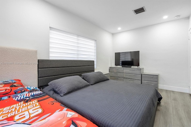 bedroom with light wood finished floors, baseboards, visible vents, and recessed lighting