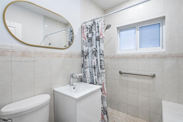 full bathroom featuring tile walls, a tile shower, vanity, and toilet