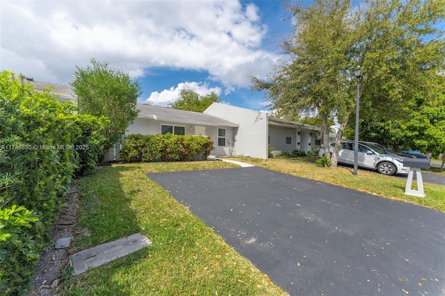 single story home featuring a front lawn and stucco siding