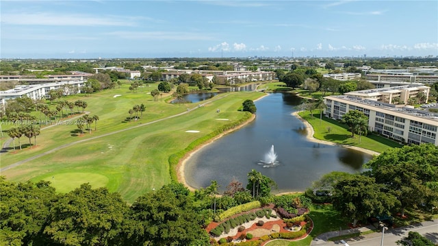 drone / aerial view with view of golf course and a water view