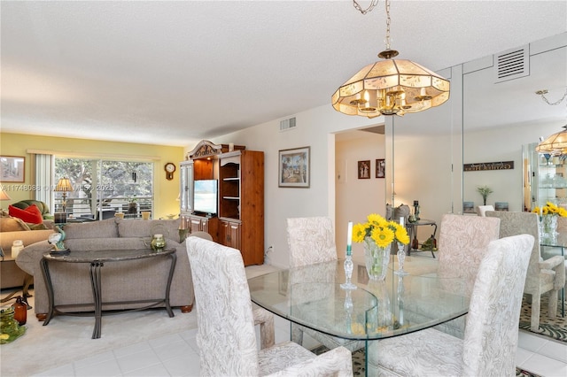 dining area featuring visible vents and a textured ceiling