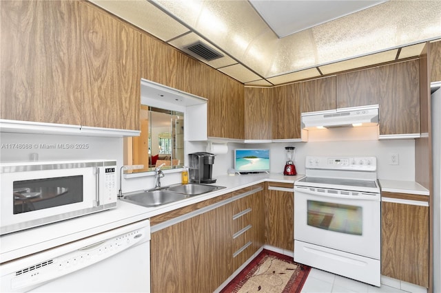 kitchen featuring visible vents, light countertops, a sink, white appliances, and under cabinet range hood