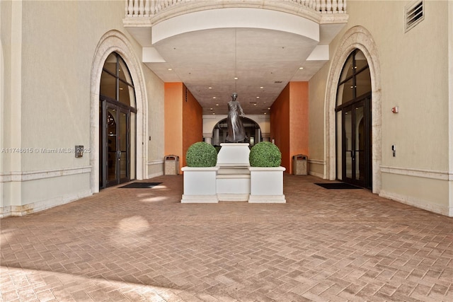 interior space with arched walkways, a towering ceiling, visible vents, and recessed lighting