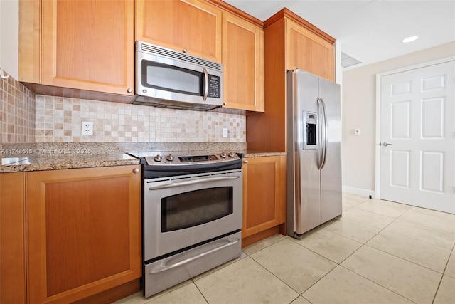 kitchen featuring recessed lighting, backsplash, appliances with stainless steel finishes, light tile patterned flooring, and light stone countertops