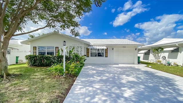 single story home featuring a garage, concrete driveway, a front lawn, and stucco siding