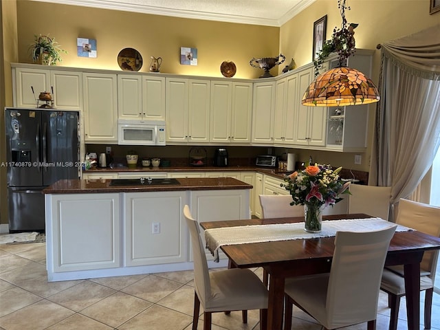 kitchen featuring dark countertops, black appliances, ornamental molding, and light tile patterned flooring