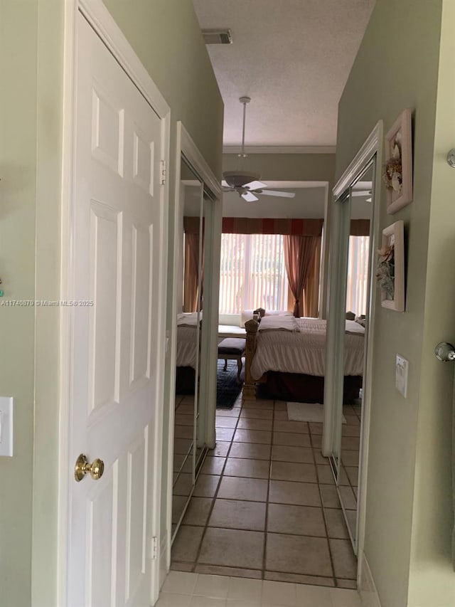 bedroom featuring light tile patterned floors, a textured ceiling, and visible vents