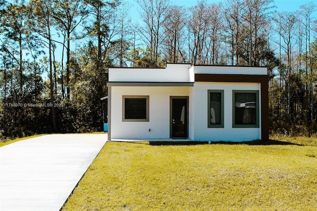 view of front of home with a front yard and stucco siding