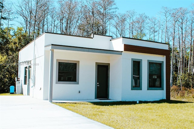 view of front of home with a front lawn and stucco siding