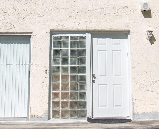 doorway to property featuring stucco siding