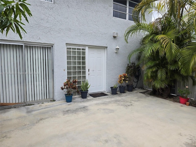 entrance to property featuring a patio and stucco siding