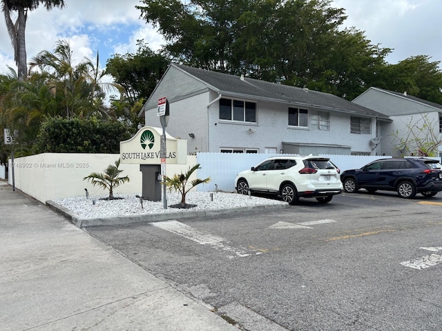 exterior space with uncovered parking and fence