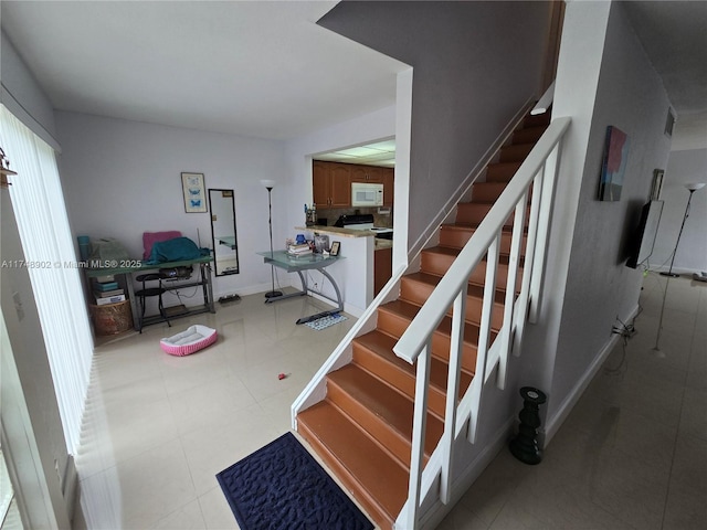 staircase with baseboards and tile patterned flooring