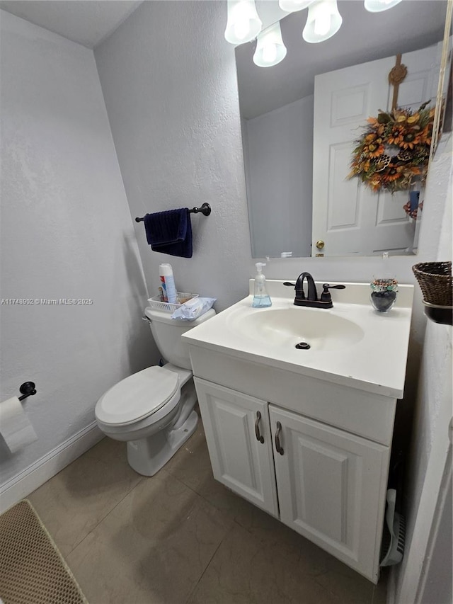 half bath with vanity, baseboards, and toilet