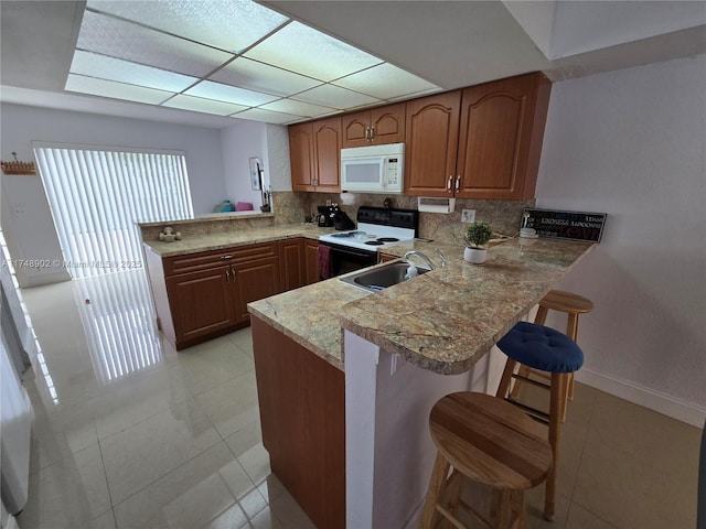 8485 SW 156th Pl Unit 106, Miami, FL 33193 - kitchen featuring electric range oven, a peninsula, white microwave, a sink, and tasteful backsplash