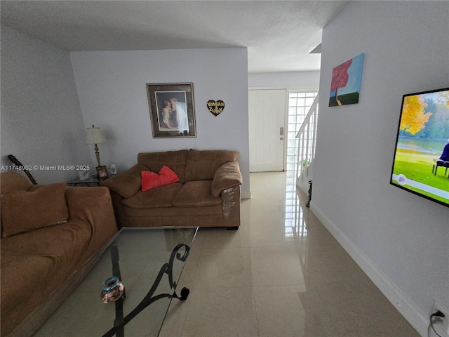 living room with baseboards and light tile patterned flooring