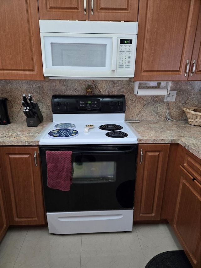 kitchen featuring electric range oven, white microwave, backsplash, and marble finish floor