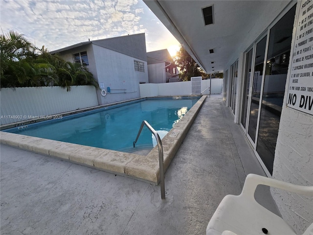 community pool with a fenced backyard