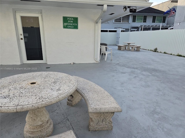 exterior space with fence, stucco siding, and a patio area