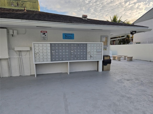 view of home's community with fence and mail area