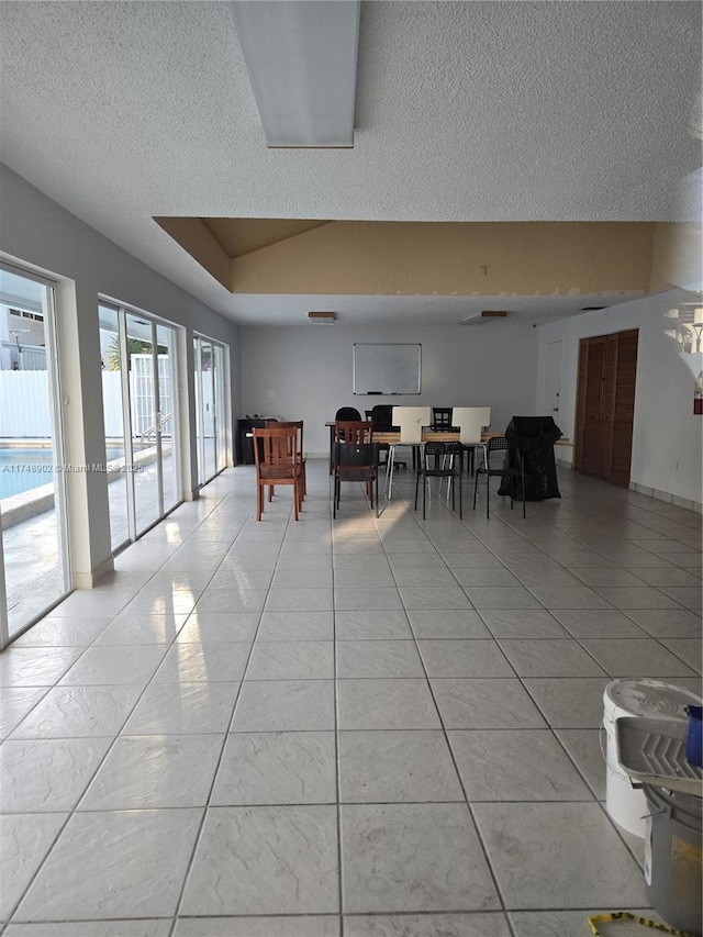 dining space with a textured ceiling and light tile patterned flooring
