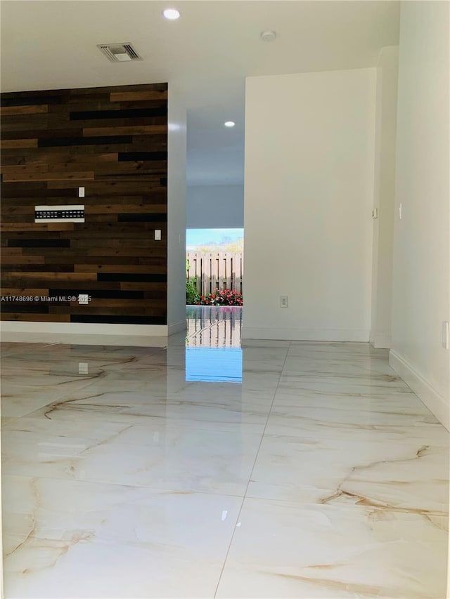 corridor featuring recessed lighting, wooden walls, visible vents, baseboards, and marble finish floor