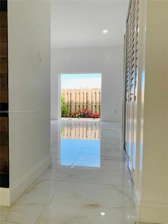 hall featuring marble finish floor and baseboards