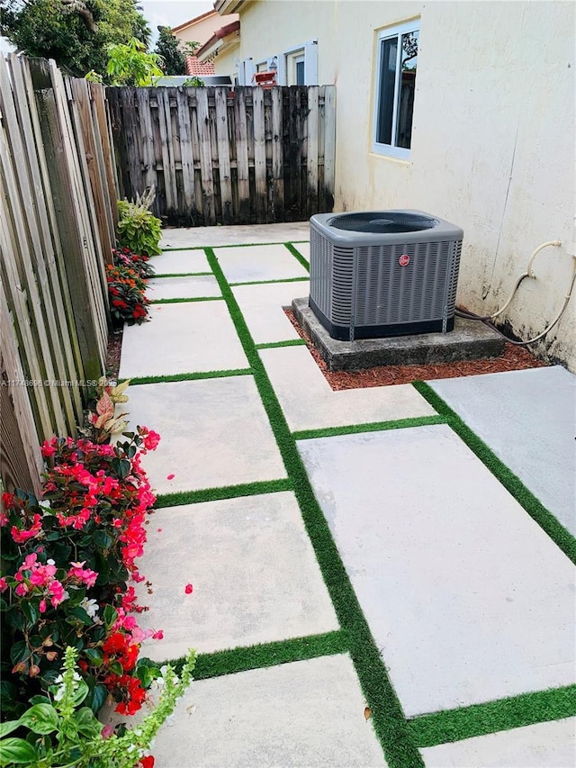 view of patio with central AC and fence