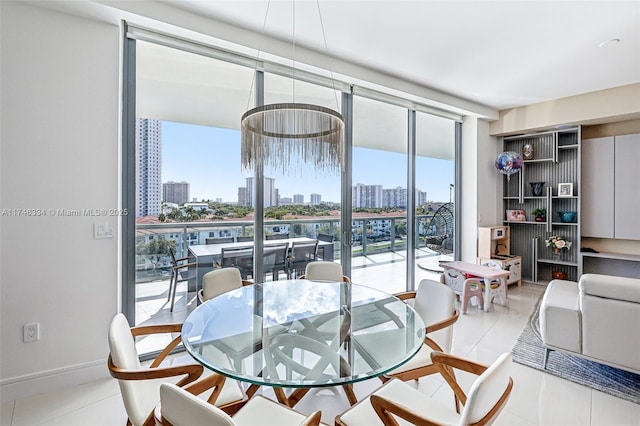 dining area featuring light tile patterned floors, baseboards, a view of city, and floor to ceiling windows