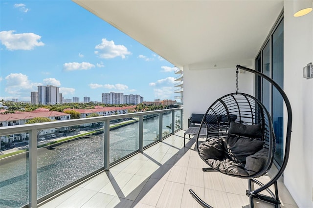 balcony featuring a water view and a city view