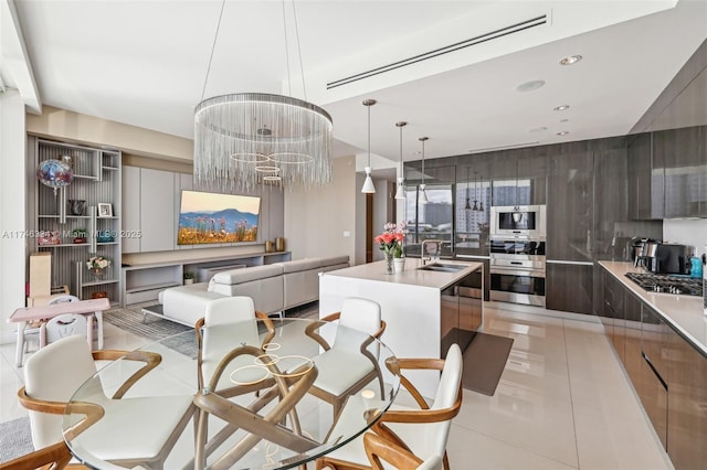 kitchen with a kitchen island with sink, modern cabinets, light countertops, and a sink