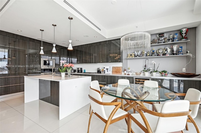 kitchen with modern cabinets, dark brown cabinetry, a center island with sink, and open shelves