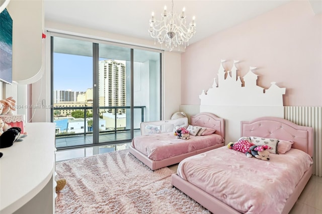 bedroom featuring a view of city, access to outside, and an inviting chandelier