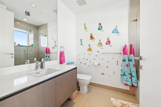 full bathroom with visible vents, toilet, vanity, tiled shower, and tile patterned floors