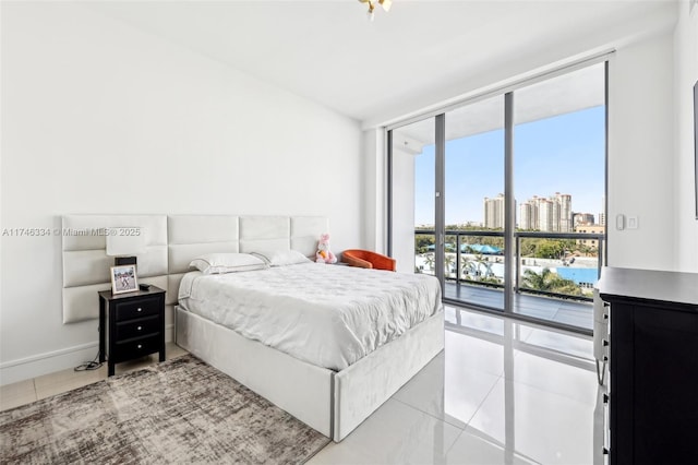 bedroom featuring light tile patterned flooring, expansive windows, baseboards, access to outside, and a view of city
