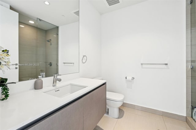 bathroom with a stall shower, vanity, toilet, and tile patterned floors