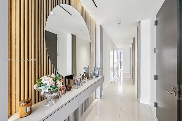 hall with light tile patterned flooring and baseboards