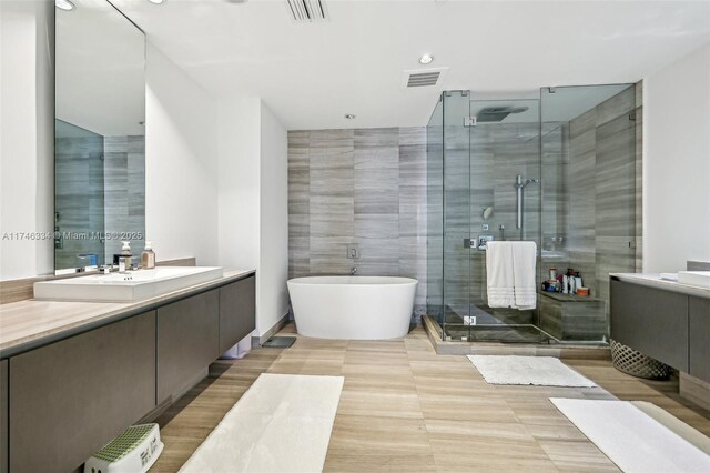 full bathroom with vanity, visible vents, and a shower stall