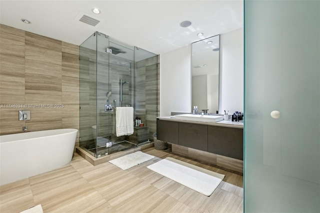 full bath featuring a freestanding tub, visible vents, a shower stall, and vanity