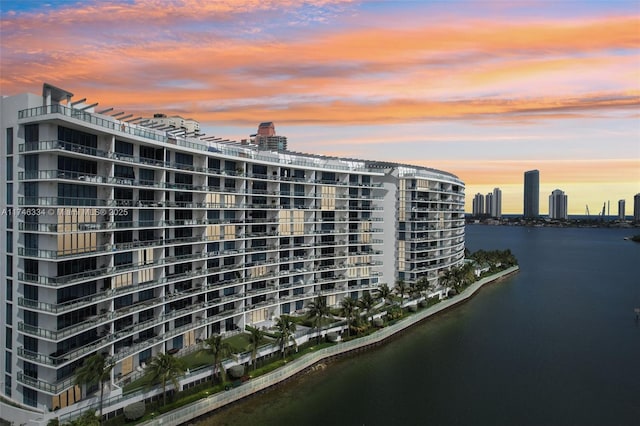 property at dusk with a view of city and a water view