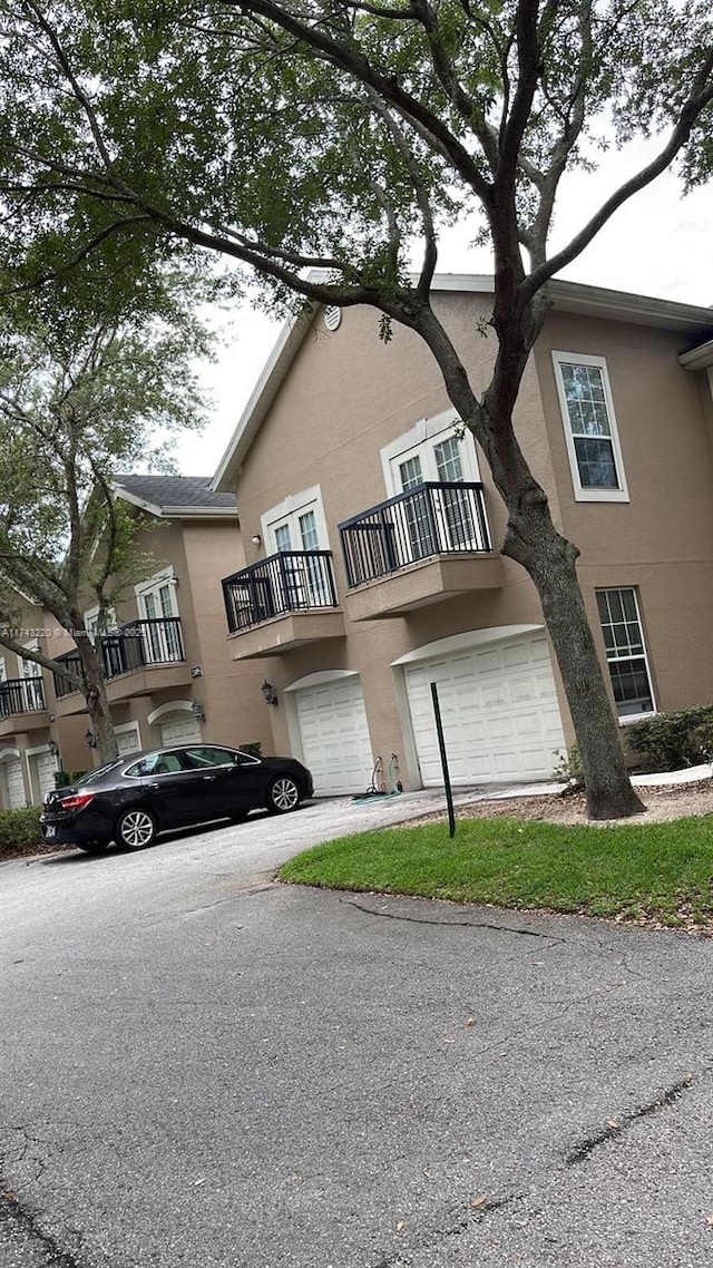 view of front facade featuring a garage, driveway, and stucco siding