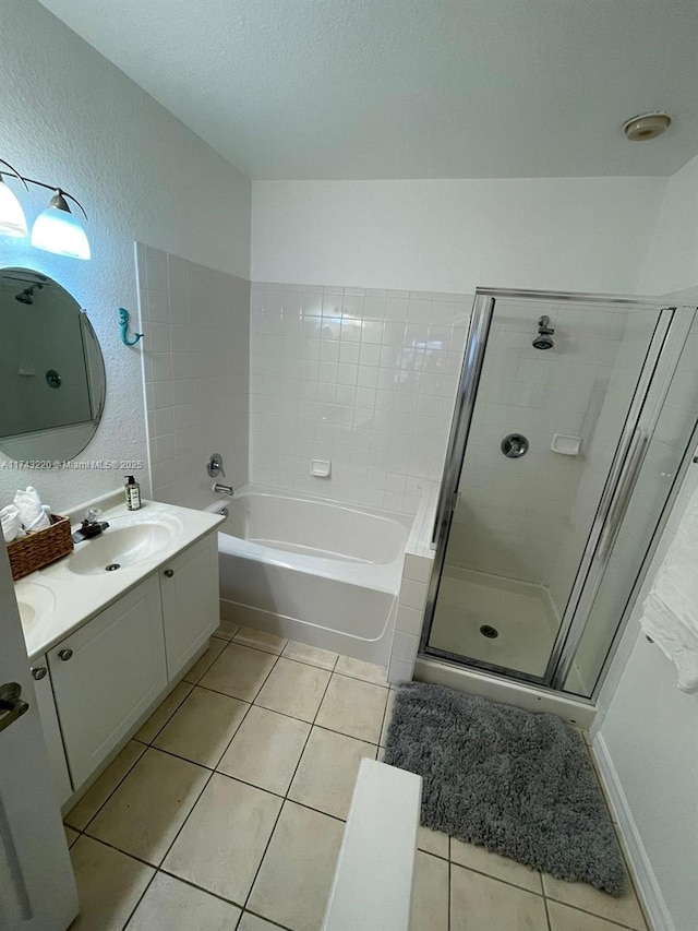 full bathroom featuring a shower stall, vanity, a bath, and tile patterned floors