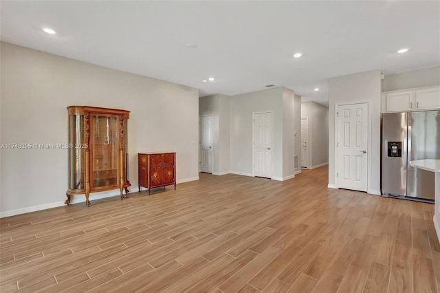 unfurnished living room with light wood-style flooring, baseboards, and recessed lighting